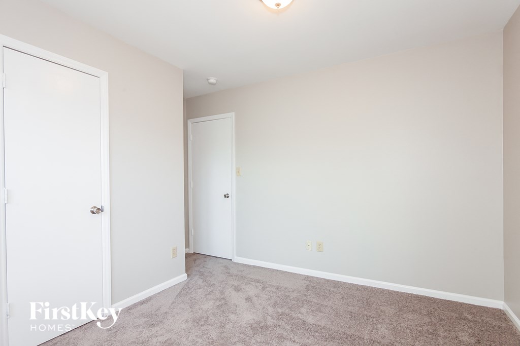 a bedroom with a carpeted floor and white doors