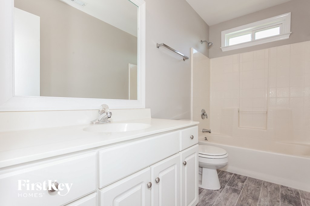 a bathroom with a white sink and a toilet and a shower