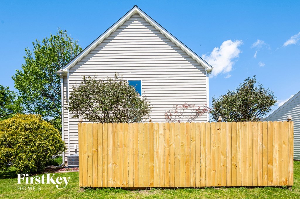 a wooden fence in front of a white house
