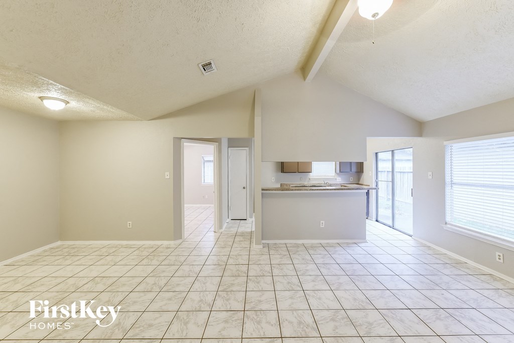 an empty kitchen and living room with a tile floor