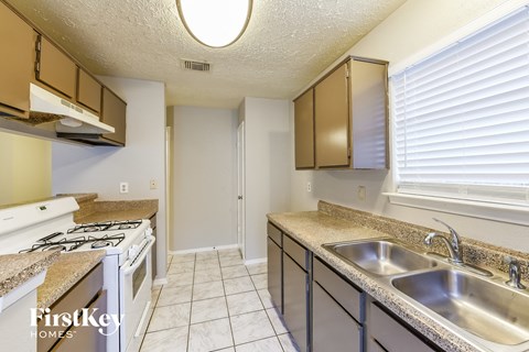 a kitchen with a stove top oven and a sink