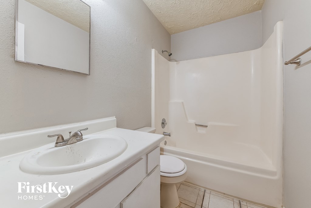 a bathroom with a sink and a shower and a toilet