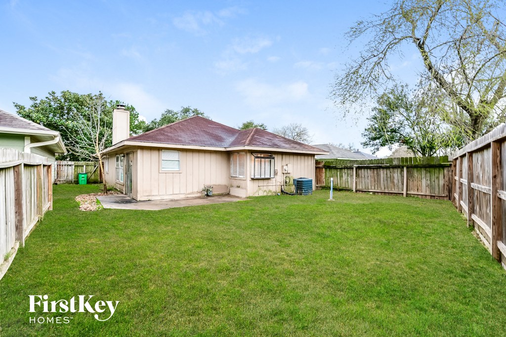 a backyard with a wooden fence and a house
