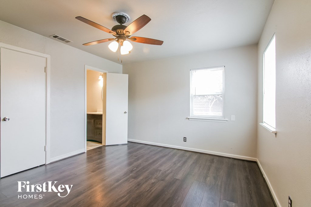 the living room of an empty house with wood flooring and a ceiling fan