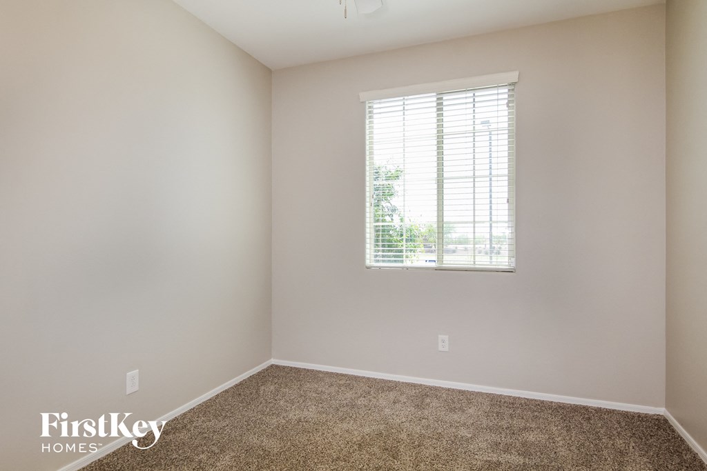 A room with a window and carpeted floor.