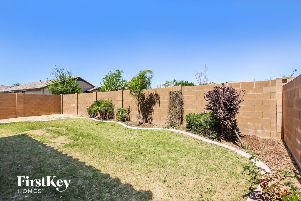 A backyard with a lawn and a fence.