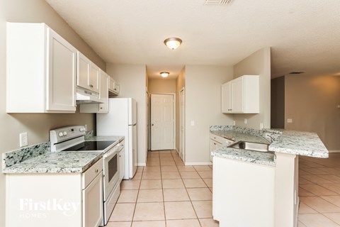 a kitchen with white appliances and granite counter tops