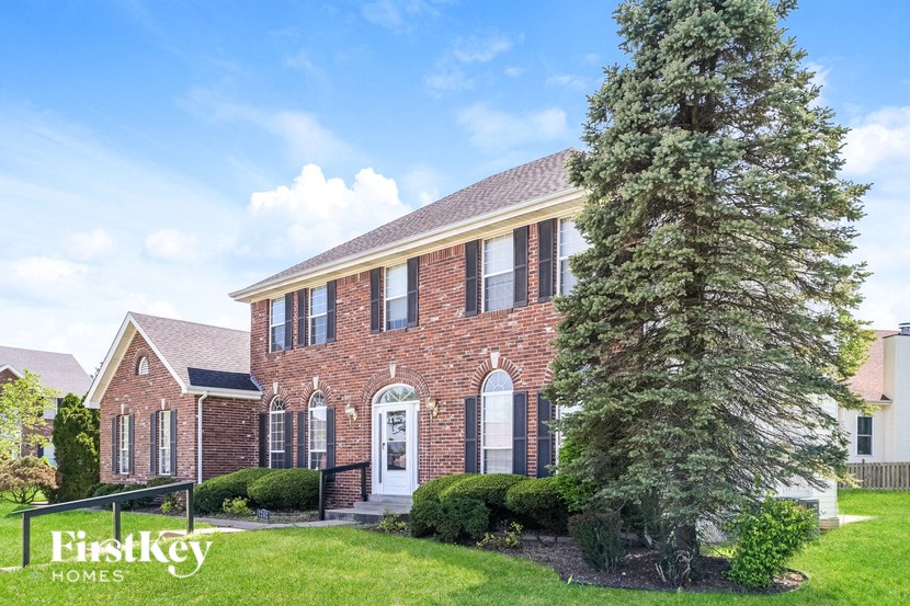 A brick house with a tree in front of it.