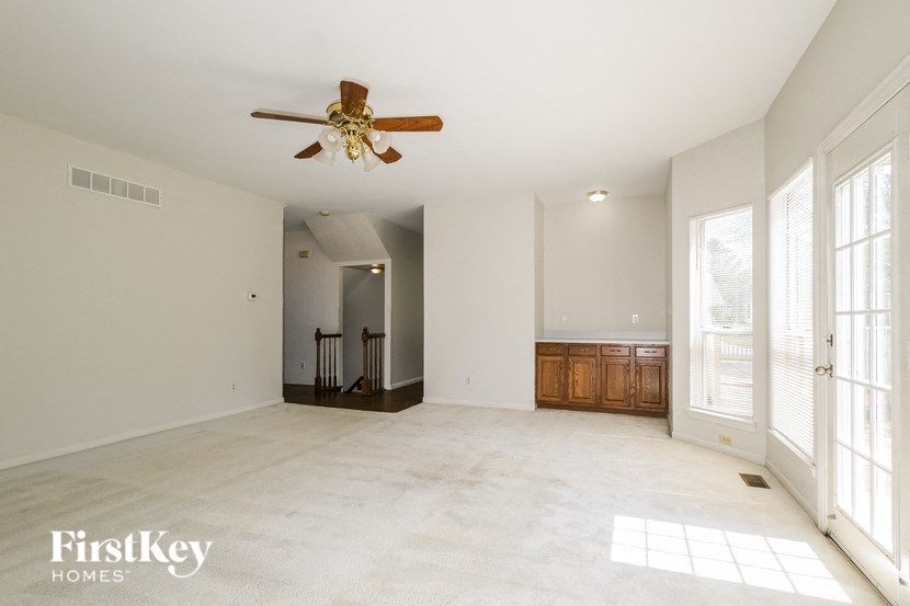 A spacious room with a ceiling fan and a cabinet.