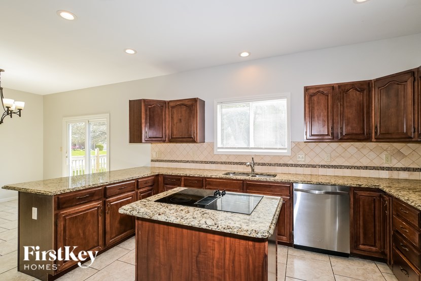 A kitchen with wooden cabinets and granite countertops.