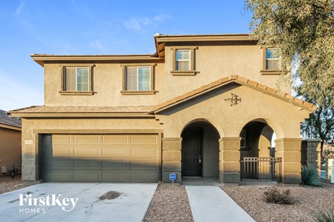 A house with a garage and a driveway in front of it.