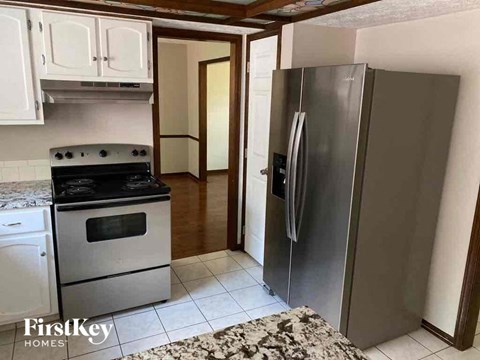 A kitchen with a stove top oven and a refrigerator.