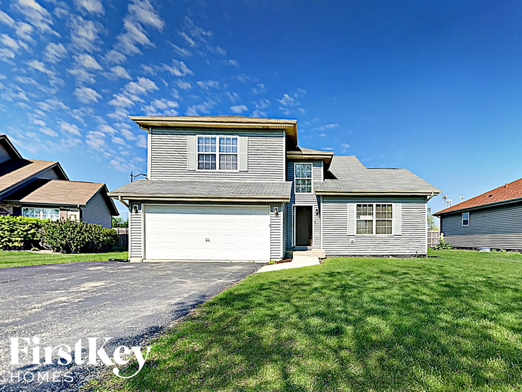 a house with a white garage door in front of a lawn