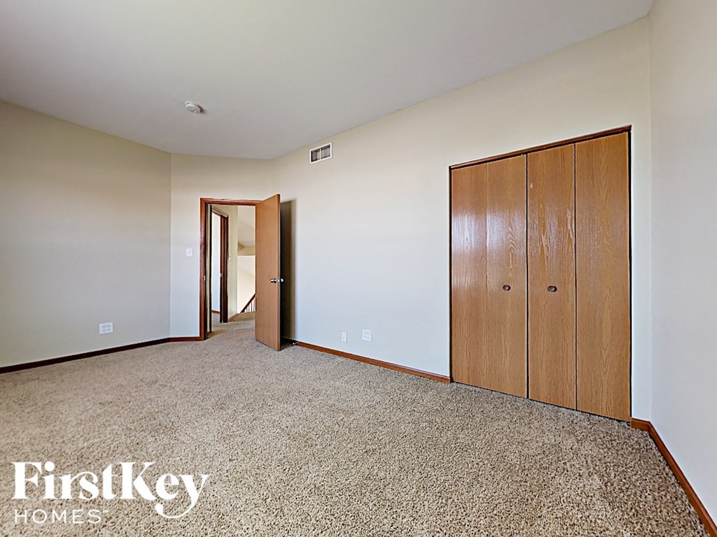 a bedroom with a closet and a door to a hallway