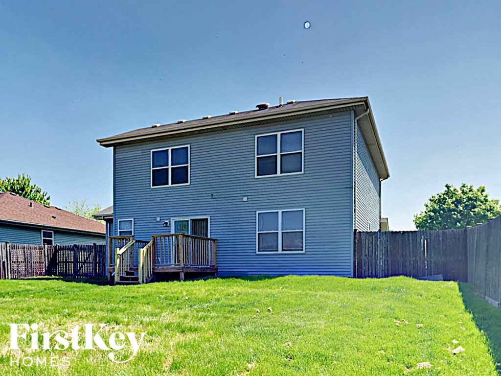 a blue house with a yard and a fence