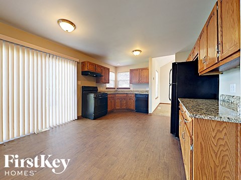 a kitchen with wooden cabinets and a black refrigerator