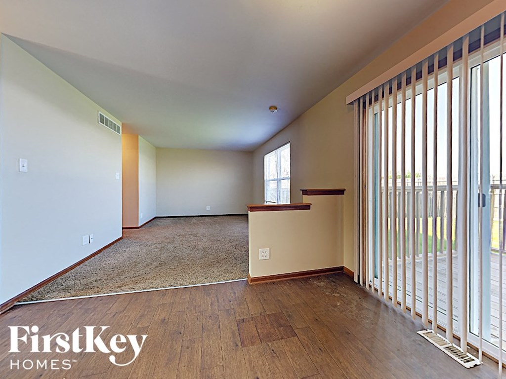 a large living room with wood flooring and sliding glass doors