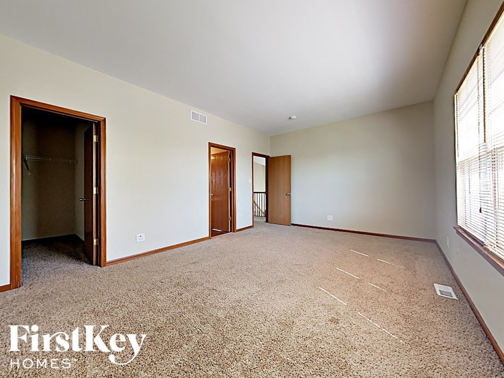 an empty living room with a door to a closet and a window