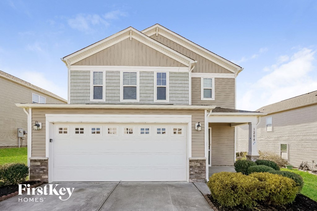 a tan house with a white garage door