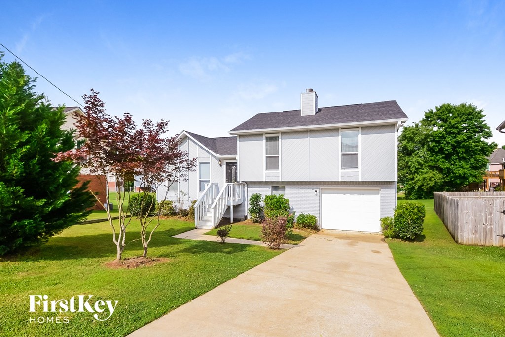 a white house with a sidewalk in front of a lawn