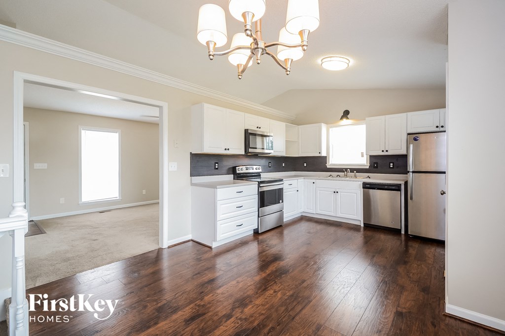 a renovated kitchen with white cabinets and stainless steel appliances