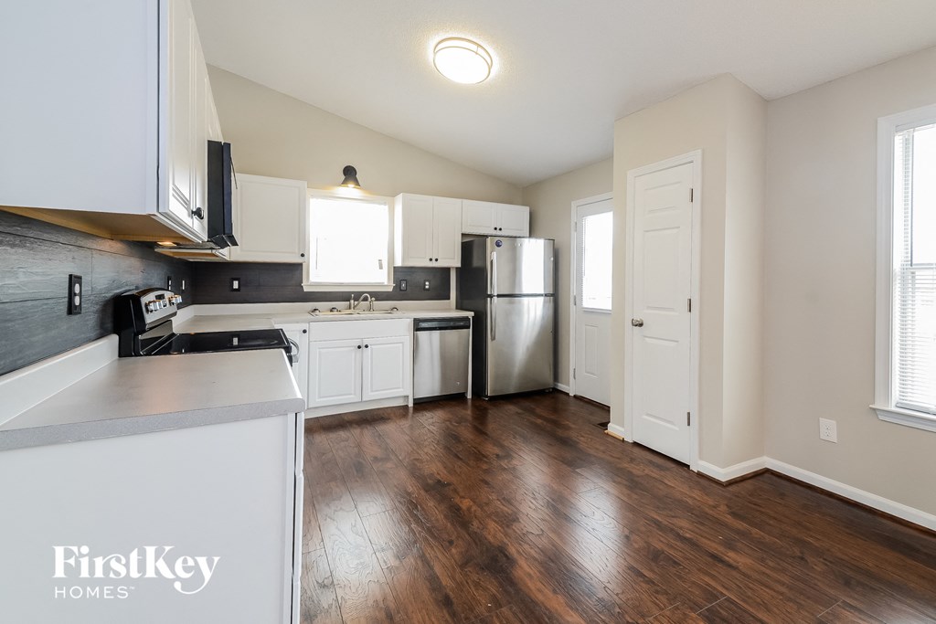 a kitchen with white cabinets and stainless steel appliances