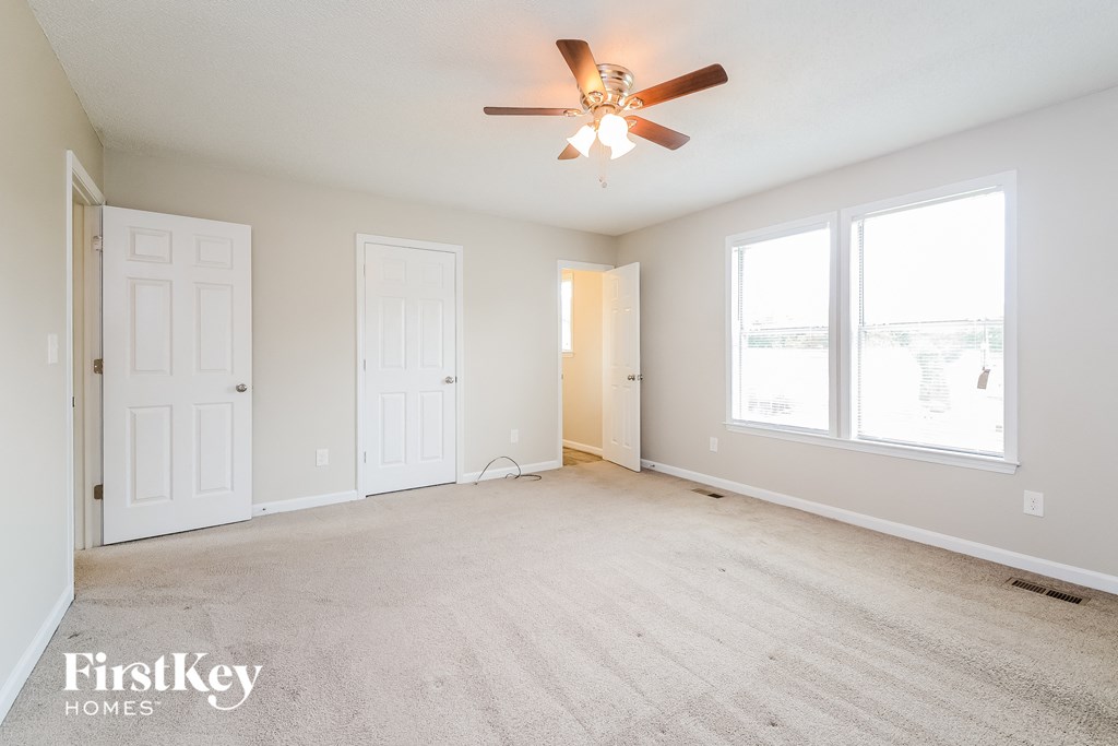 the living room of an empty home with a ceiling fan