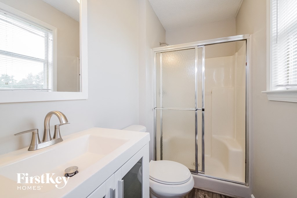 a bathroom with a shower and a sink and a toilet