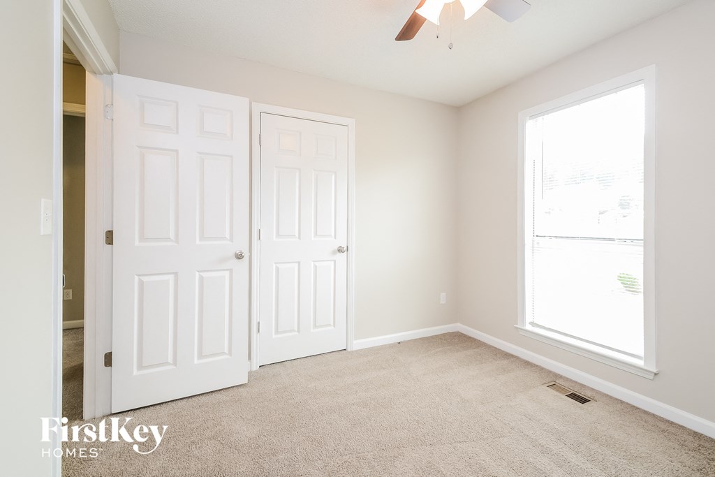 a bedroom with two closets and a carpeted floor
