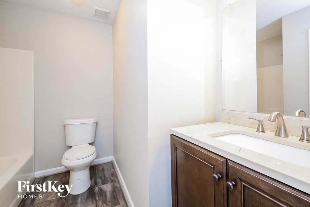a bathroom with a toilet and a sink and a mirror