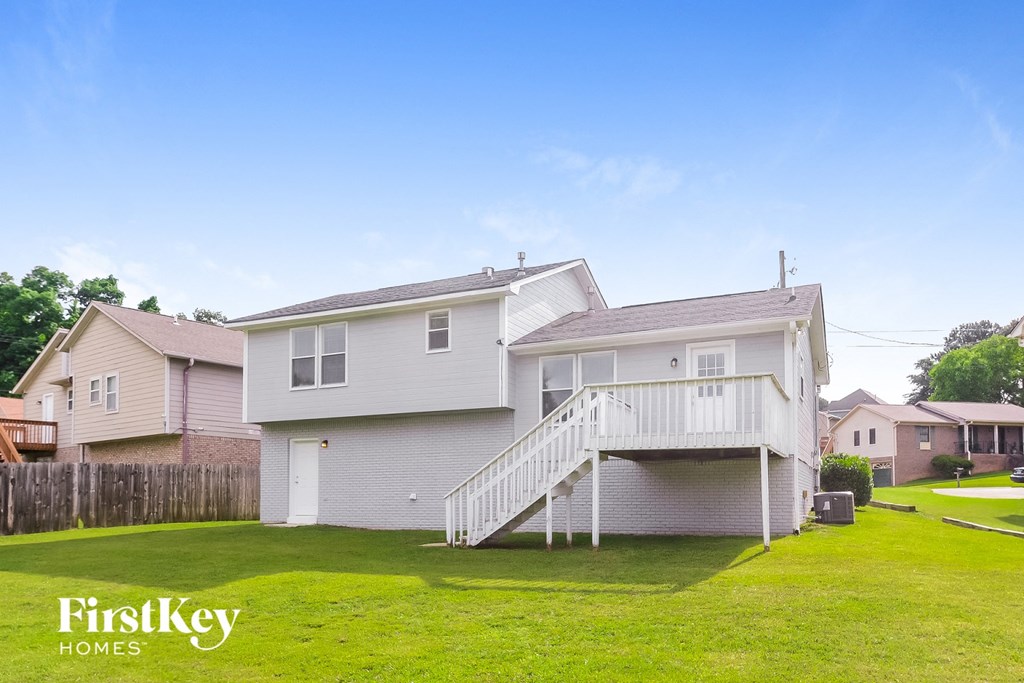 a white house with a white deck and a grassy yard