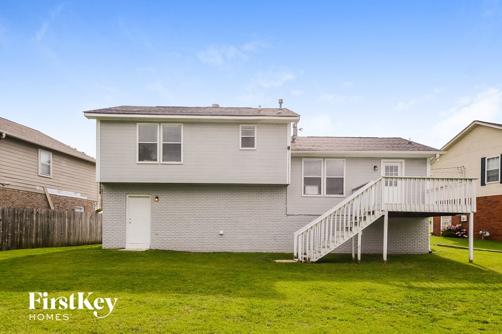 a white house with a white deck and a green yard