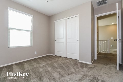 a bedroom with two closets and a door to a staircase
