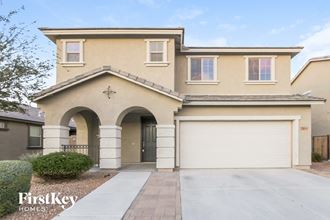 a beige house with a garage door and a driveway