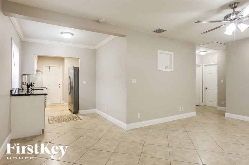 A spacious room with a kitchenette and a refrigerator.