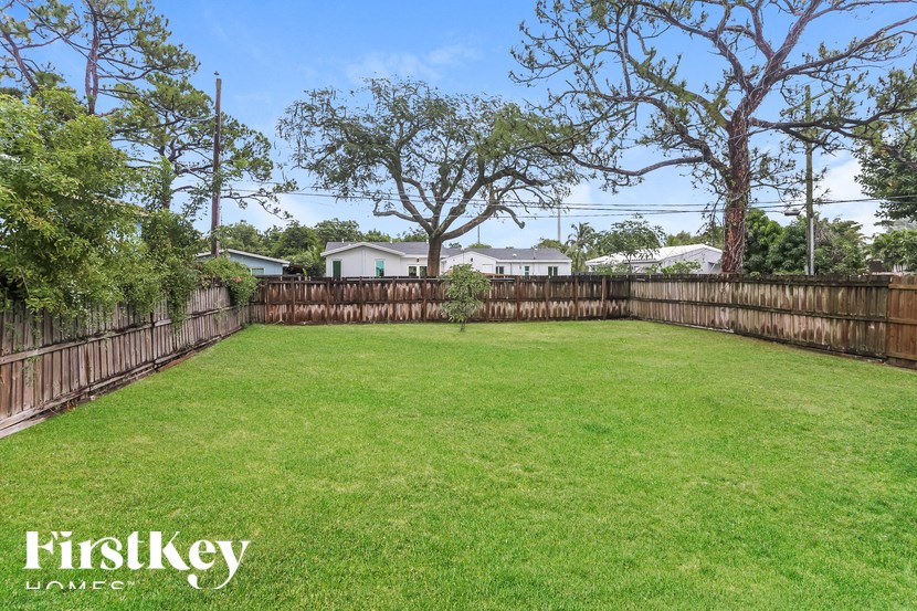 A backyard with a fence and trees.