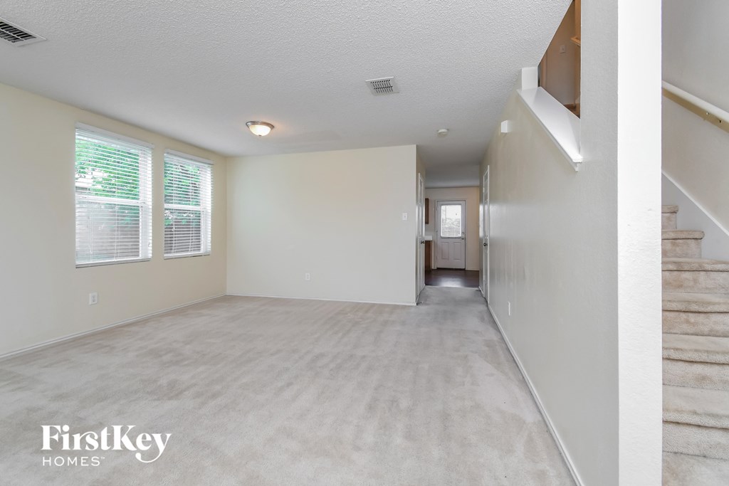 the living room and hallway of an empty house