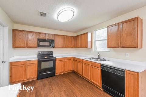 a kitchen with wooden cabinets and black appliances