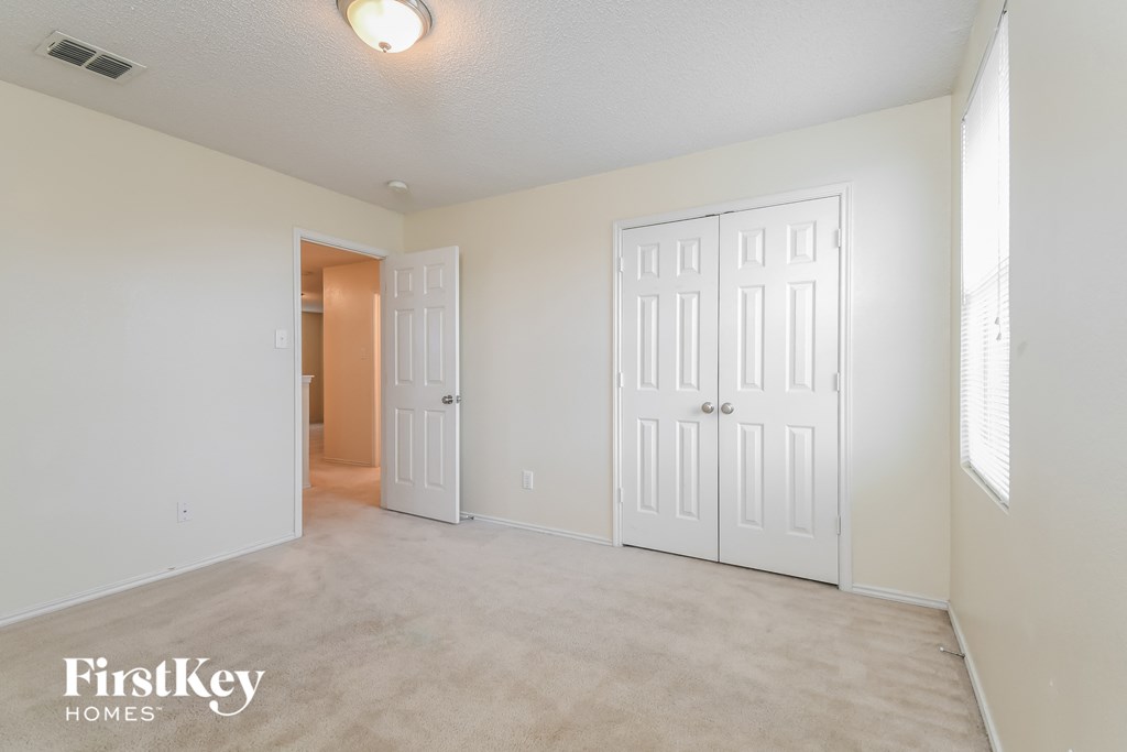 a bedroom with two closets and a door to a hallway