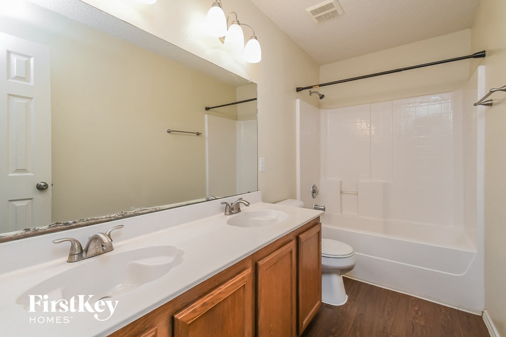 a bathroom with two sinks and a tub and a toilet