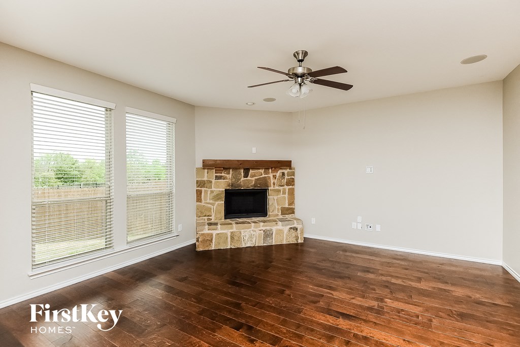 a living room with a fireplace and a ceiling fan