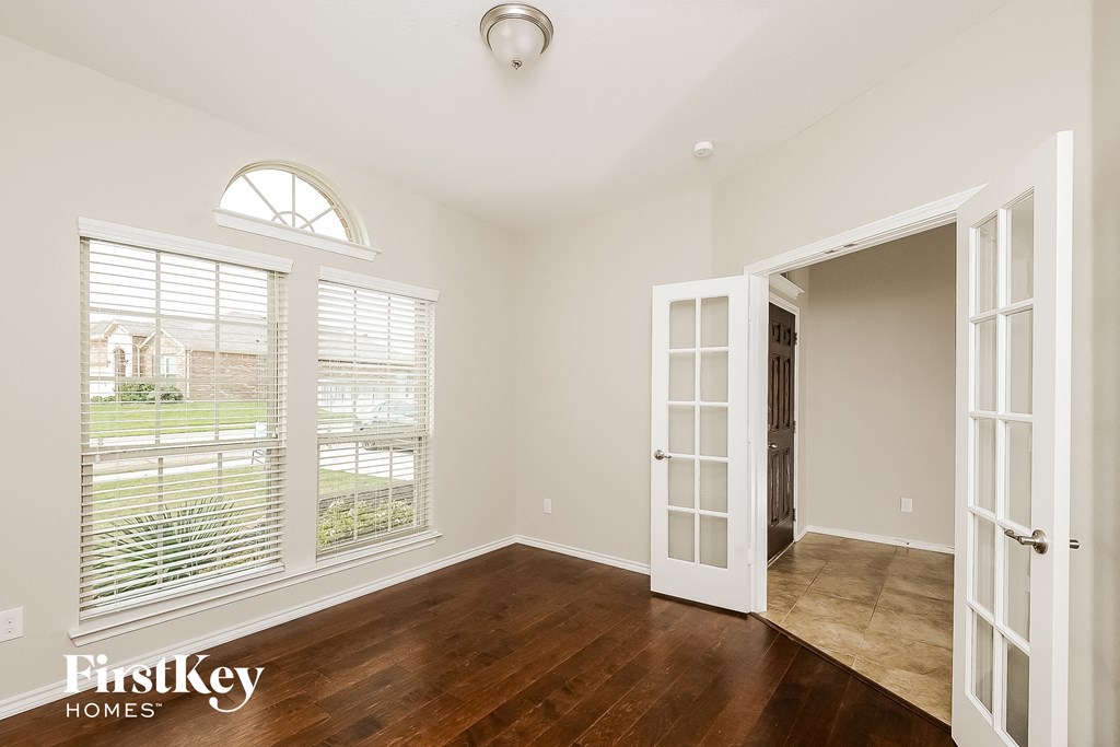 a living room with a large window and a door to a hallway
