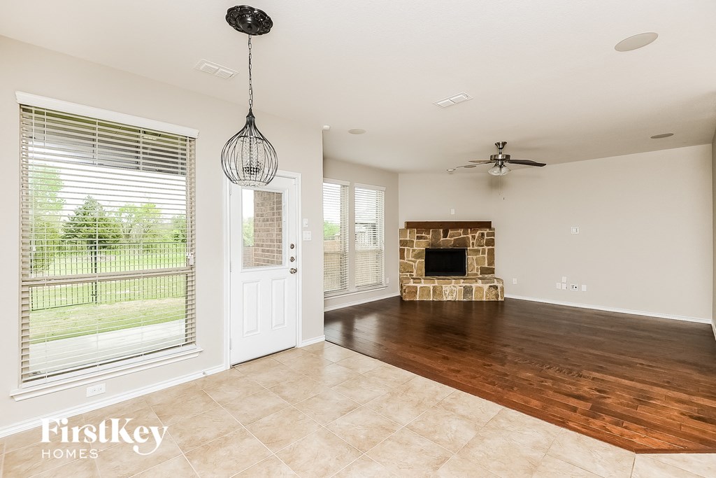 an empty living room with a fireplace and a door to a patio