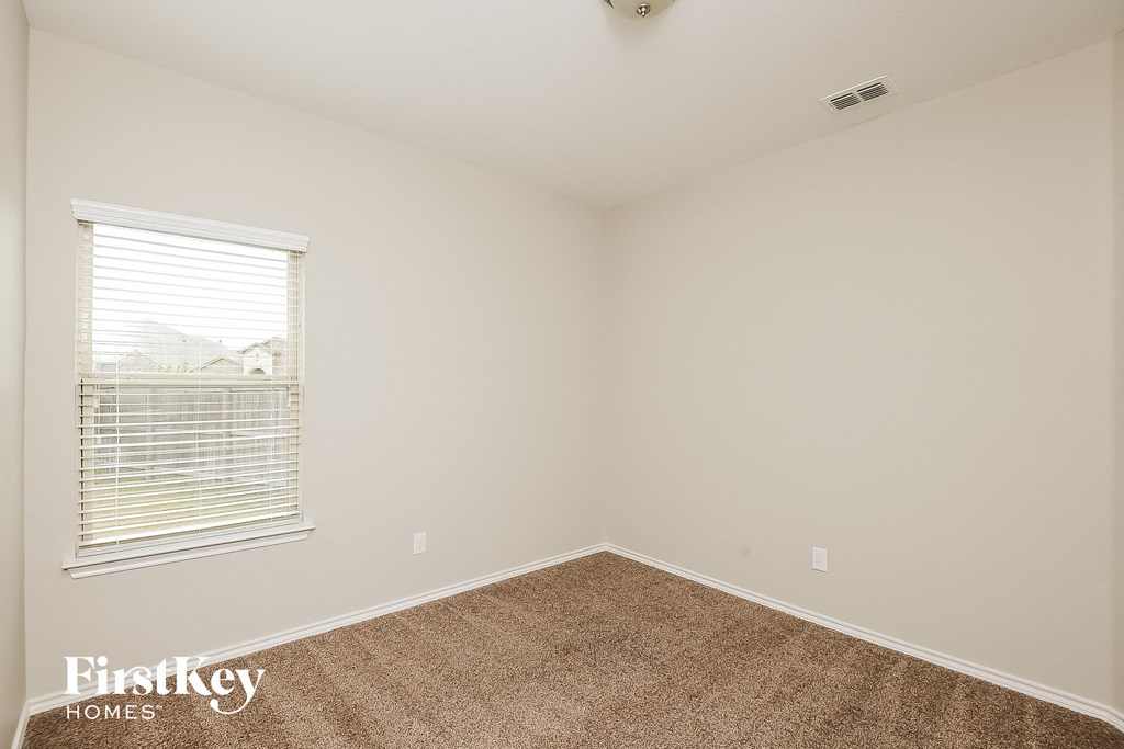 a bedroom with a large window and a carpet