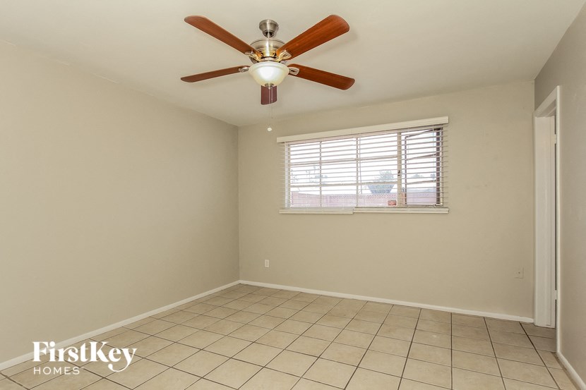 a empty room with a ceiling fan and a window