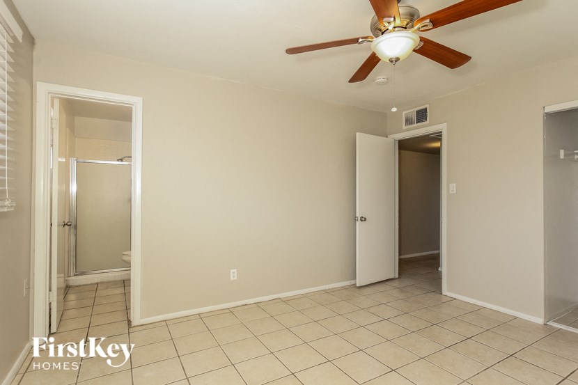 a empty living room with a ceiling fan and a door to a closet