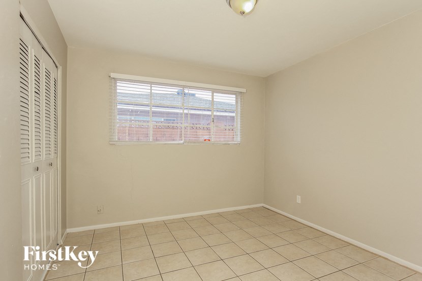 an empty room with a window and a tiled floor
