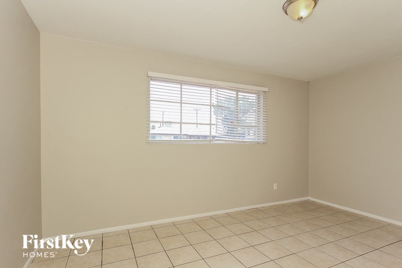 an empty room with a window and a tiled floor