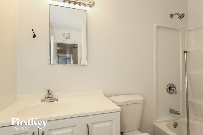a bathroom with a sink toilet and a mirror