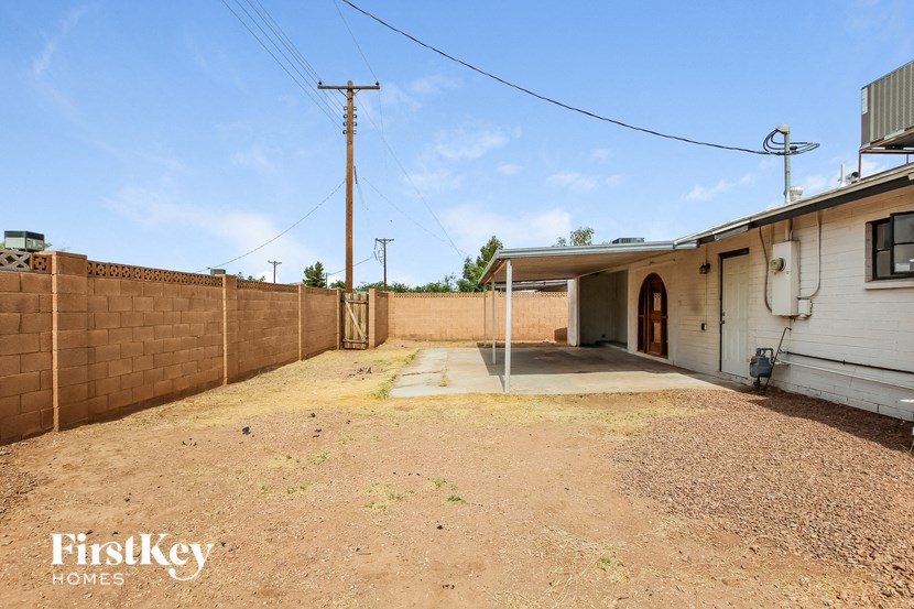the backyard of a house with a driveway and a fence